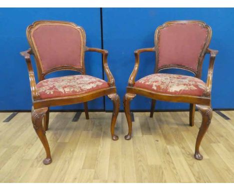 A pair of early to mid twentieth century walnut parlour armchairs with petite point tapestry covers and shell carved legs. Be