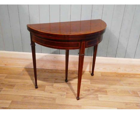 An Edward VII mahogany demi-lune fold over card table with train track boxwood stringing, 76 cm W