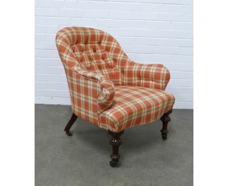 An upholstered button back armchair with mahogany legs and brass castors, , 65 x 76 x 52cm. 