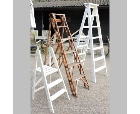 A collection of three wooden step ladders