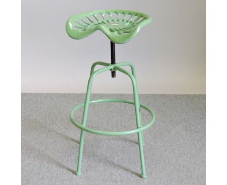 A green painted tractor seat stool