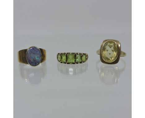 A 9 carat gold peridot five stone ring, together with an opal cabochon ring and another