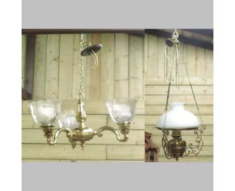 An early 20th century brass hanging oil lamp, with a white glass shade, together with a brass three branch chandelier, with g