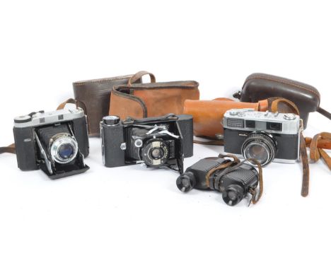 A mid 20th century circa 1960s Minolta AF 35mm rangefinder camera alongside other 20th century camera / optics examples. The 