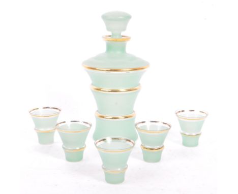 An mid 20th century Art Deco style decanter and five shot glasses. The decanter and glasses in frosted green glass with gilt 