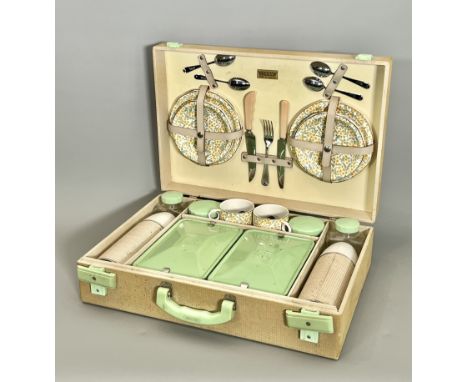 A 1950s Brexton picnic set - the canvas covered case with light green 'bakelite' handle and locks, complete with all contents