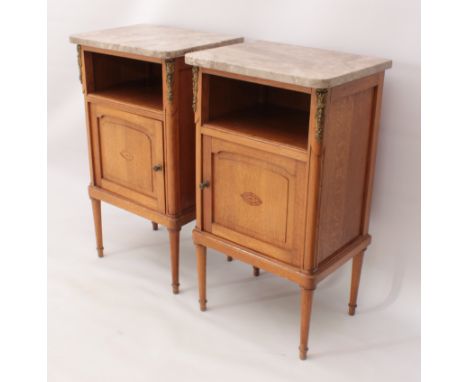 A pair of French honey oak, marquetry and marble bedside cabinets - early 20th century, each with an open shelf above an arch