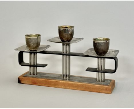 A mid-century German teak and silver plated three light candelabra - the ovoid nozzles over square drip pans, on a reeded and