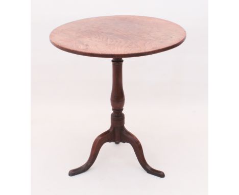 An early 19th century oak tripod table - the circular top on a turned baluster column, to three chamfered, swept supports wit
