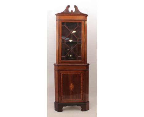 An Edwardian inlaid mahogany part-glazed corner cabinet - the swan-neck pediment with central satinwood banded tablet over a 