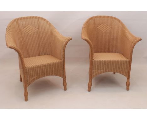 A pair of contemporary Lloyd Loom armchairs - natural wicker finish, metal 'Lloyd Loom' plaques to lower back, 68cm wide, 85.