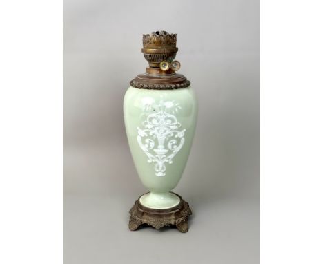 A porcelain pate-sur-pate oil lamp - early 20th century, the ovoid, celadon glazed vase with white bas relief decoration of a