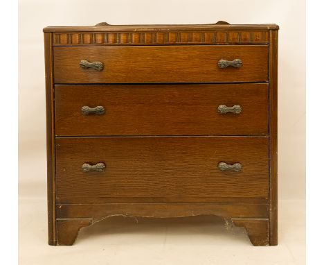 A mid-century oak chest of drawers by Lebus - with shaped upstand to the moulded back, over a fluted frieze and three long gr