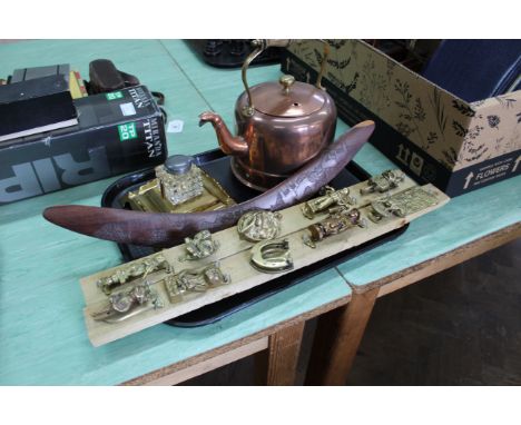 A tray with an electrified copper kettle, two displays of brass door knockers, brass and glass inkwell plus an Australian boo