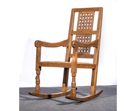 Robert 'Mouseman' Thompson of Kilburn, circa 1970, an adzed oak rocking chair, lattice panel back, tan leather seat, width 51