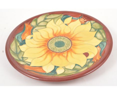 Sally Tuffin for Moorcroft, 'Sunflower' a shallow circular dish, 1995, wooden surround, stamped Pottery marks,30cm diam, seco