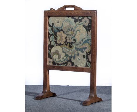 Robert 'Mouseman' Thompson of Kilburn, a fire screen, circa 1950, adzed oak frame with handle to wavy carved top rail, inset 