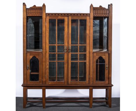 A Gothic Revival oak bookcase cabinet, circa 1880, the cornice with geometric designs, central glazed cupboards flanked by fu