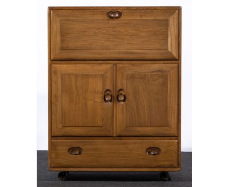 Ercol, a Serving Cabinet, circa 1965, model 430, elm and beech, with fall front enclosing shelf compartments above cupboard w