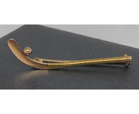 An antique brooch modelled as a hockey stick and ball, marked '15', length 50mm, wt. 3.5g. 