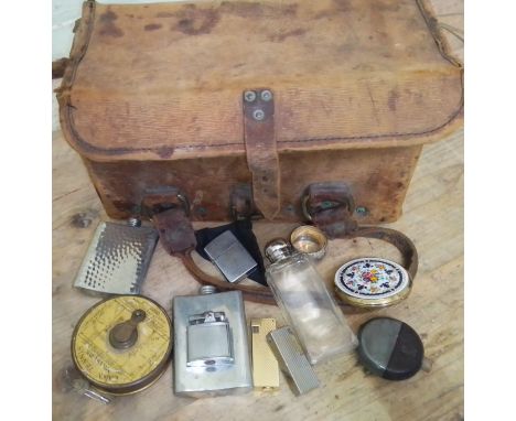A vintage tool bag containing assorted collectables to include a lawn tennis measure, hip flasks, lighters &amp; a compact et