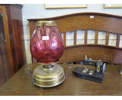 A Victorian brass oil lamp, with tulip shape cranberry glass shade 42cm high and a 'Vulcan' miniature sewing machine