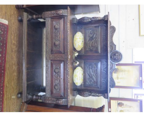 A Victorian carved oak buffet, the raised back with lion mask, dragon carved panels and figural supports over a top with two 
