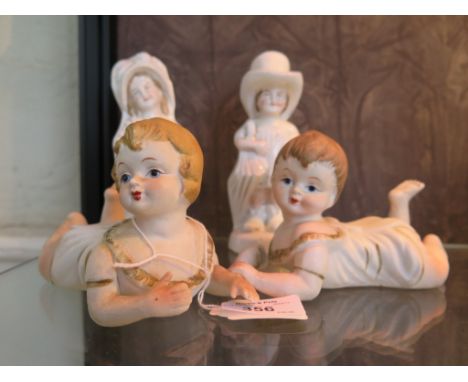 A pair of Gebruder Heubach bisque piano babies 14cm long, and a pair of German porcelain figures (4)