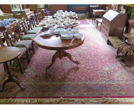 A Heriz style carpet, with red field, radiating medallion and lanterns filled with floral scrolls and multiple border, machin