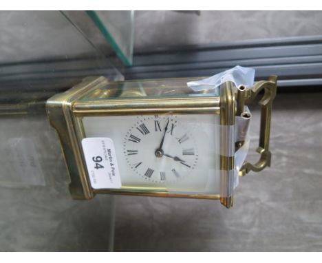 An Edwardian brass carriage clock of conventional form with enamel dial, the twin train movement striking on a gong, 15cm hig
