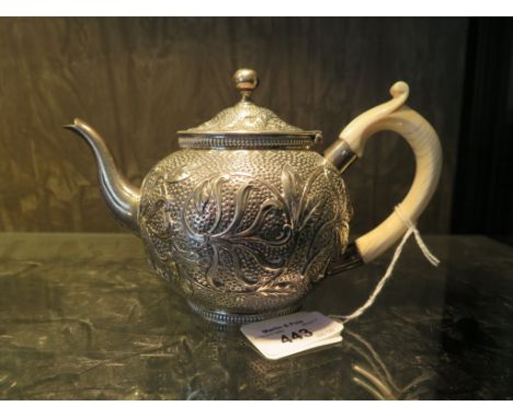 A Victorian silver bachelor's teapot with ivory handle, the teapot decorated in relief with flower tendrils, London 1880, mak