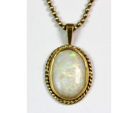 A yellow metal (tested 18ct gold) mounted opal pendant on a 9ct gold chain.