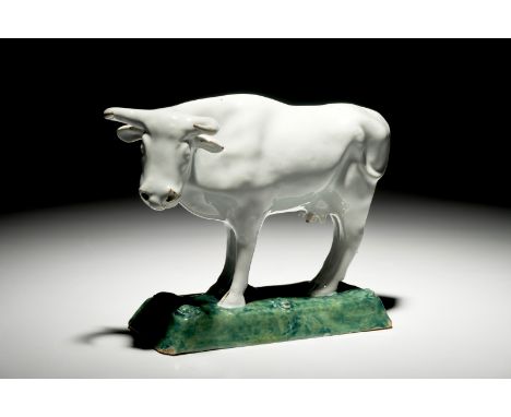 A white Dutch Delft model of a cow on a green base, 18th C. H.: 15,5 cm - L.: 22 cm We have more lots available for bidding o