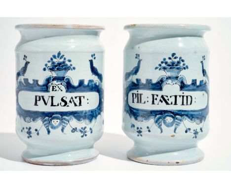 A pair of French faience Delft style albarello drug jars, Lille, 18th C. H.: 12,5 cm - Dia.: 8,5 cm We have more lots availab