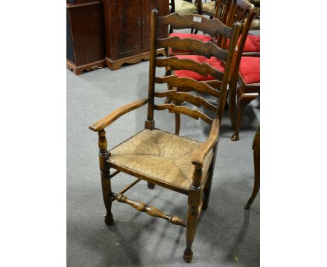 Set of oak ladder-back dining chairs, by Titchmarsh & Goodwin, wavy rails, rush seats, comprising an elbow chair, width 54cm 