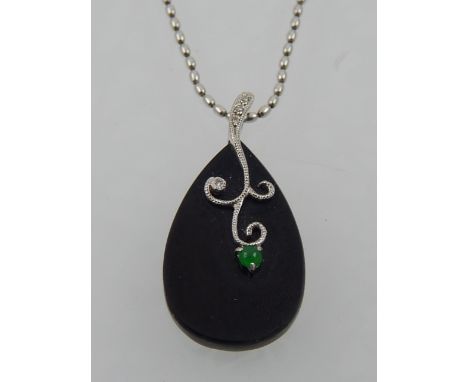 An 18 carat white gold and black onyx pear-shaped pendant, set with diamond accents and a small cabouchon jade, suspended on 