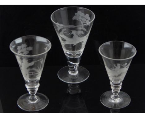 A trumpet shaped clear wine glass, engraved with a hunting scene, H. 16cm, together with two similar smaller, (3).