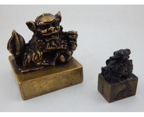 A Chinese bronze desk seal of square form mounted with a kylin, together with a small bronze seal decorated with a kylin and 