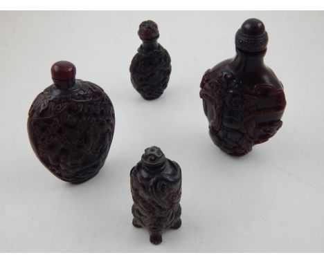 A collection of Chinese resin snuff bottles of various sizes, decorated with scrolling foliage, Buddhas and men playing board