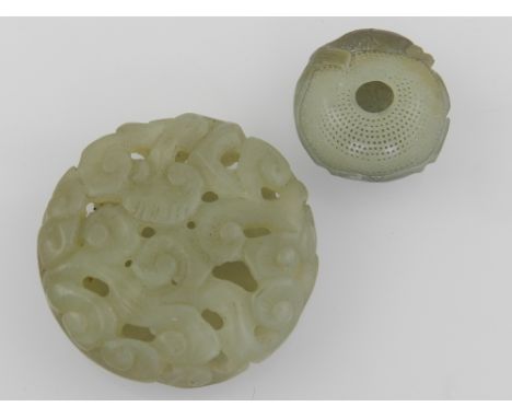 A Chinese green jade carving of a goldfish and a flower, together with a circualr reticulated jade carved pendant. (2)