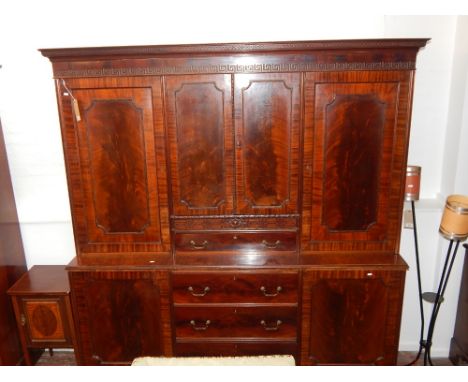 A George III style mahogany side cabinet, the Greek key cornice above and arrangement of four panel doors, the base with thre