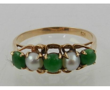 A 10 carat yellow gold, pearl, and jade five stone ring. 