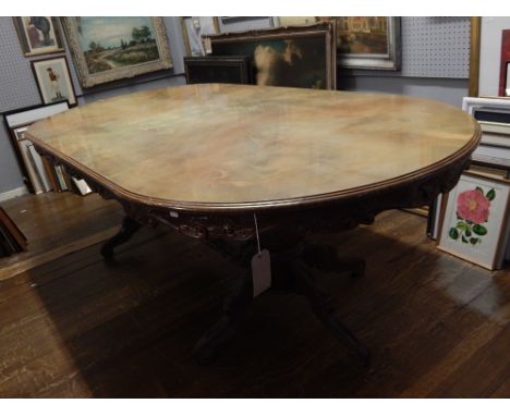 A 20th century walnut and inlaid dining table, the rectangular top with rounded ends above a carved shaped frieze, on twin tu