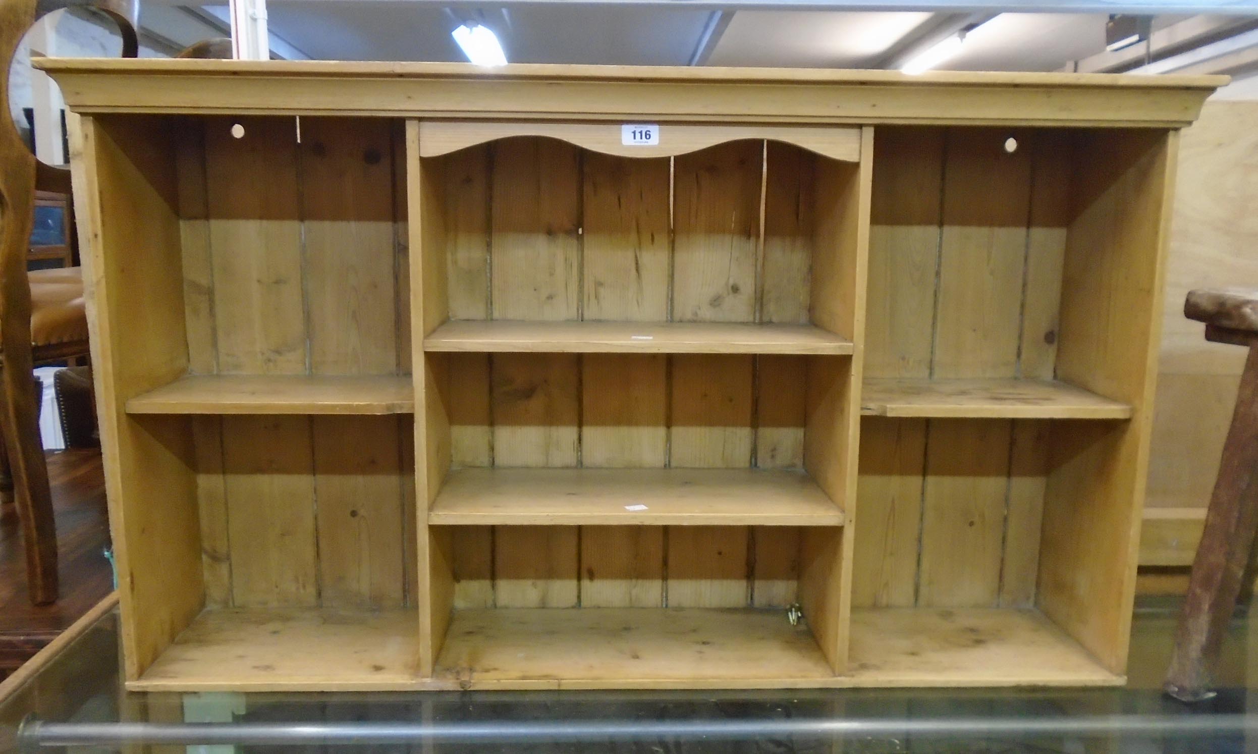 A 4' waxed pine wall mounted open shelf unit with moulded top and seven