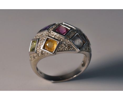 A multi gem, diamond, topaz, citrine, amethyst etc cluster ring, tapering arched body inset with seven different coloured sto