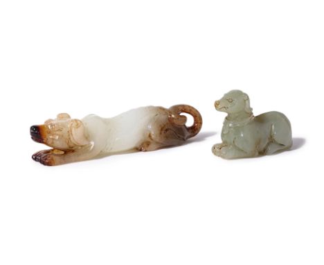 TWO JADE CARVINGS OF A DOGS
One example modelled lying with front paws outstretched, its head slightly raised, with carved ri