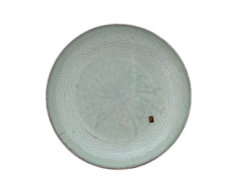 A CARVED CELADON GLAZED DISH
Qing Dynasty, probably 18th/19th Century, the shallow dish finely potted with rounded sides, car