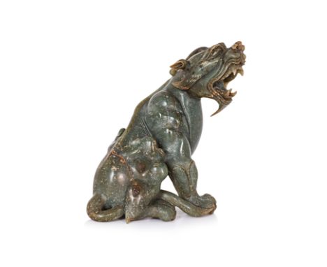 A JADE CARVING OF A MYTHICAL BEAST Well modelled, sitting and turning slightly, mouth open wide showing teeth 16cm high Condi