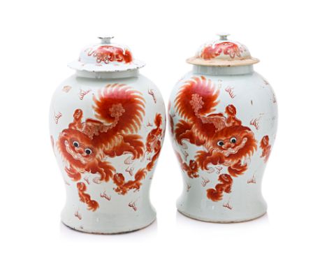 AN OPPOSING PAIR OF IRON RED FOO DOG JARS AND COVERS Late 19th/20th Century, of baluster shape, decorated with a large foo do