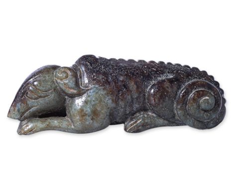 A JADE CARVING OF A RECUMBENT DOG
In the Song/Ming style, modelled with it's head resting on outstretched paws, the body with